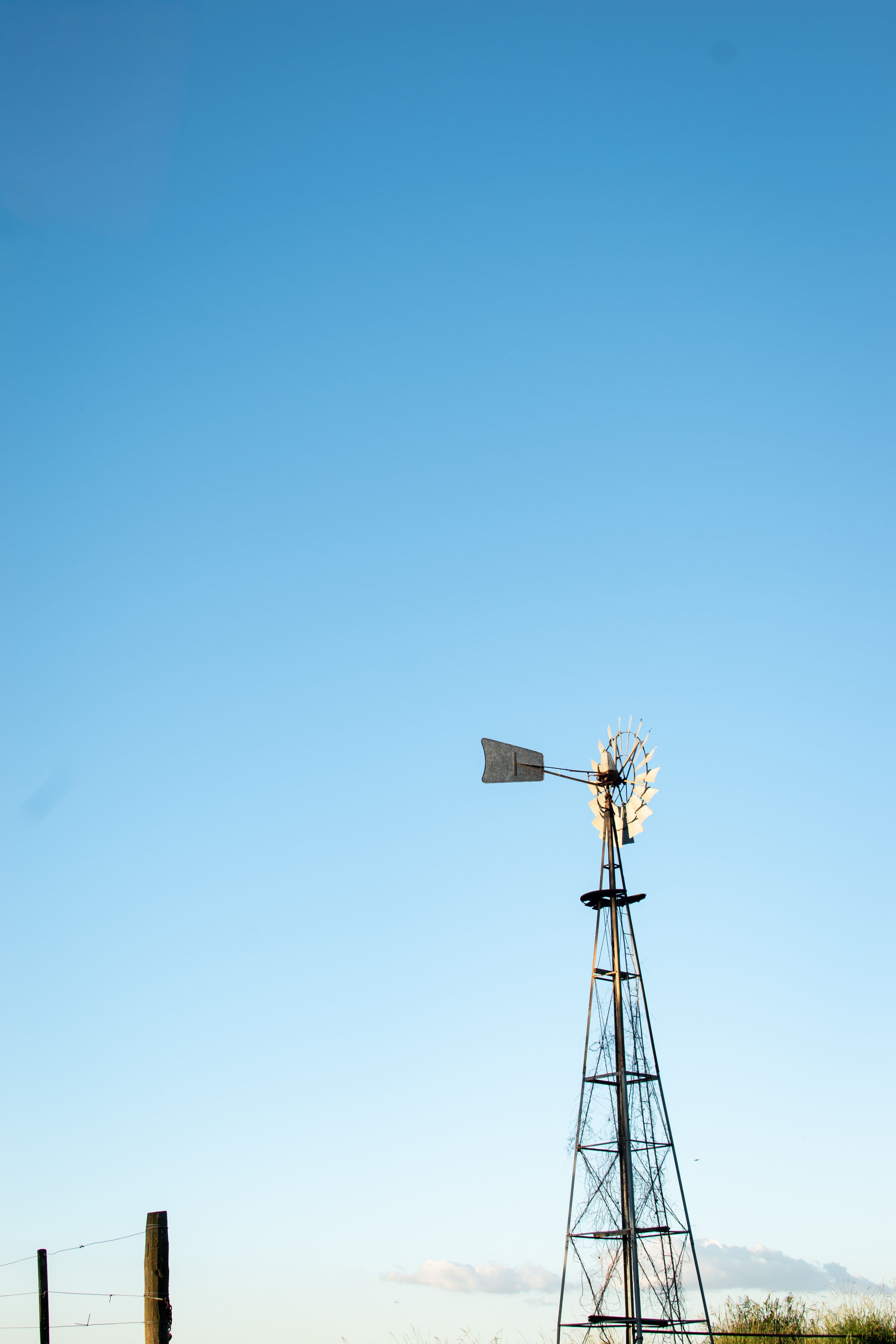 A farm borehole windmill drawing groundwater against a clear sky