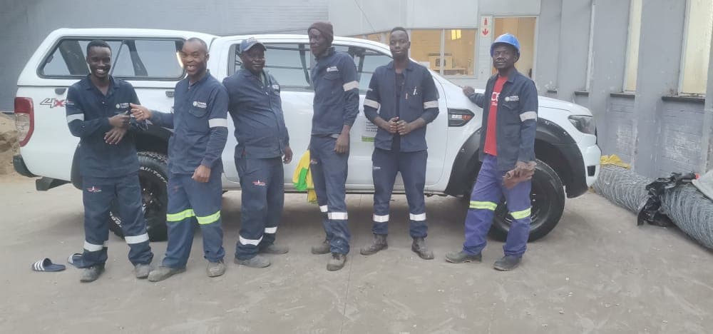 Yanga site team beside a company vehicle