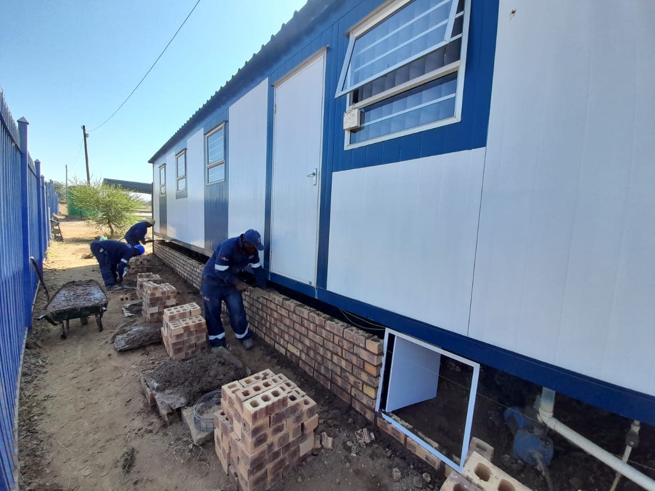 Yanga team laying brick skirting to park home units on site